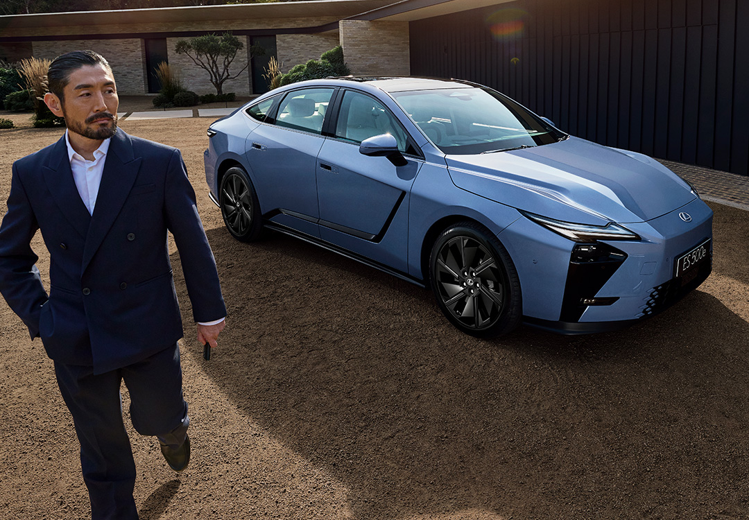 A man walks beside a parked Lexus ES