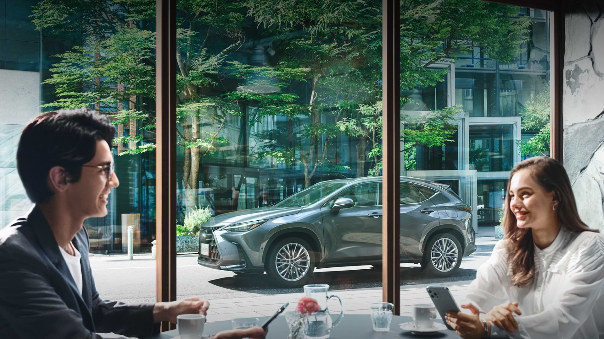 NX 350h outside a cafe while man and woman sit inside.