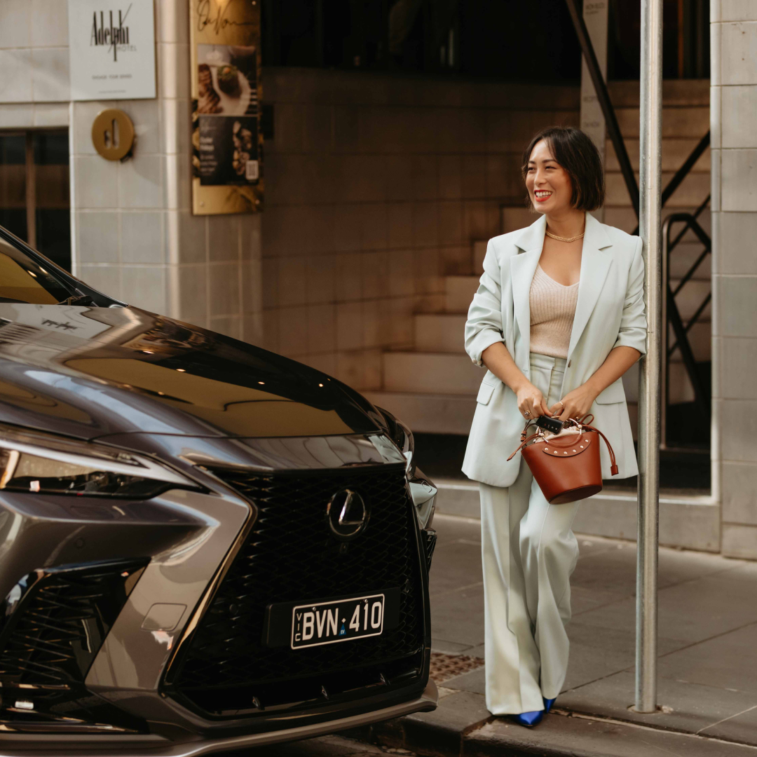 Melissa Leong outside standing against a pole, admiring the 2022 Lexus NX.