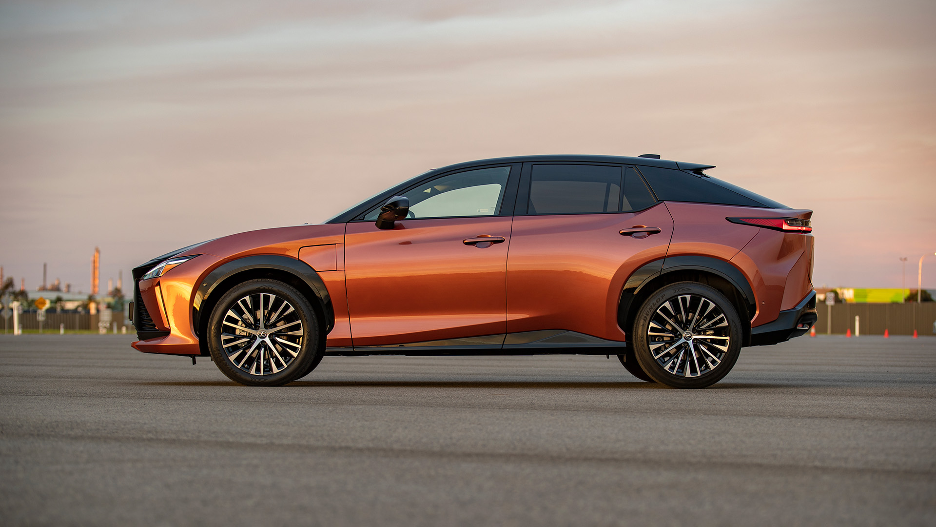 The side of an orange Lexus RZ 450e