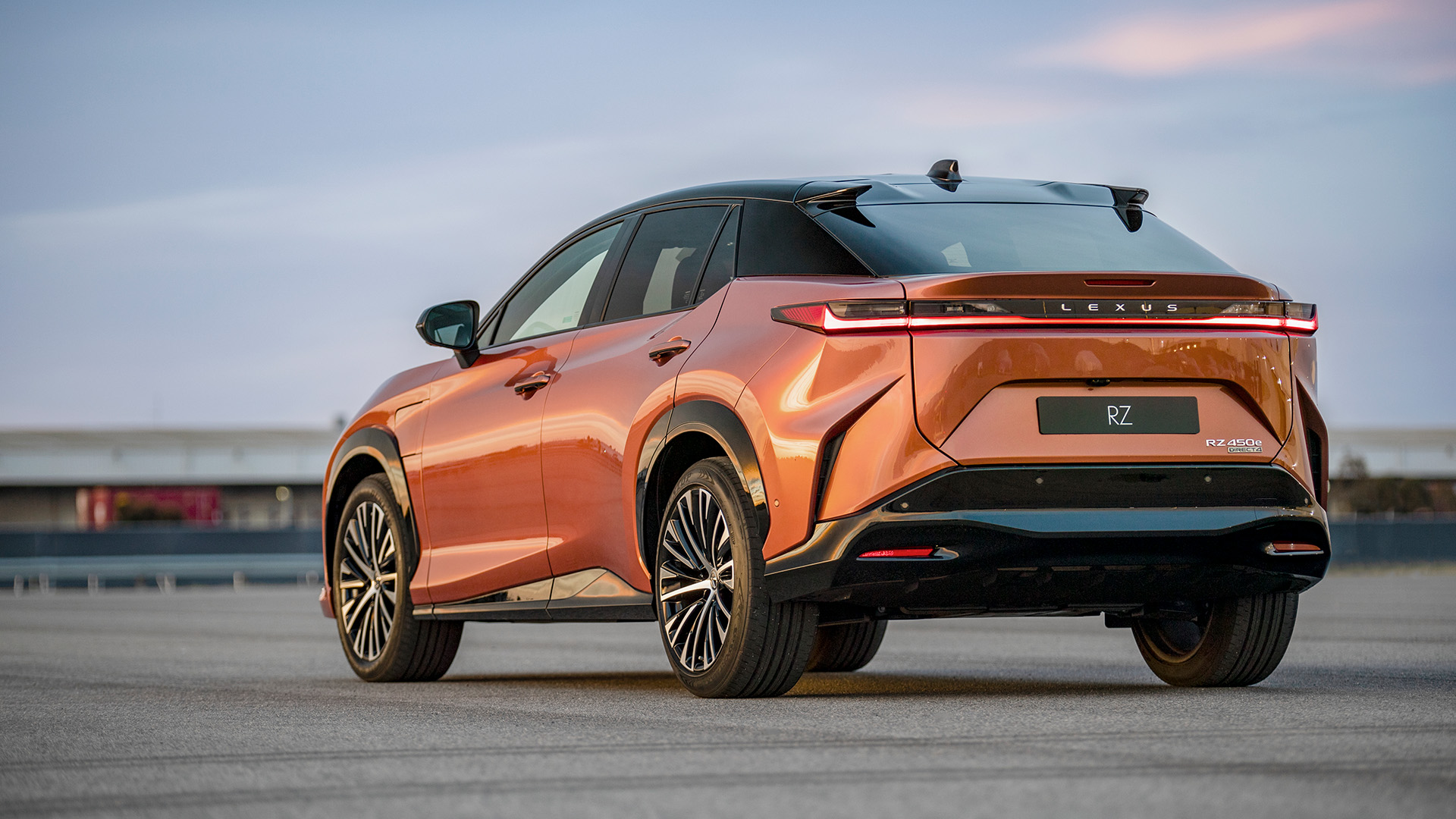 The rear of an orange Lexus RZ 450e